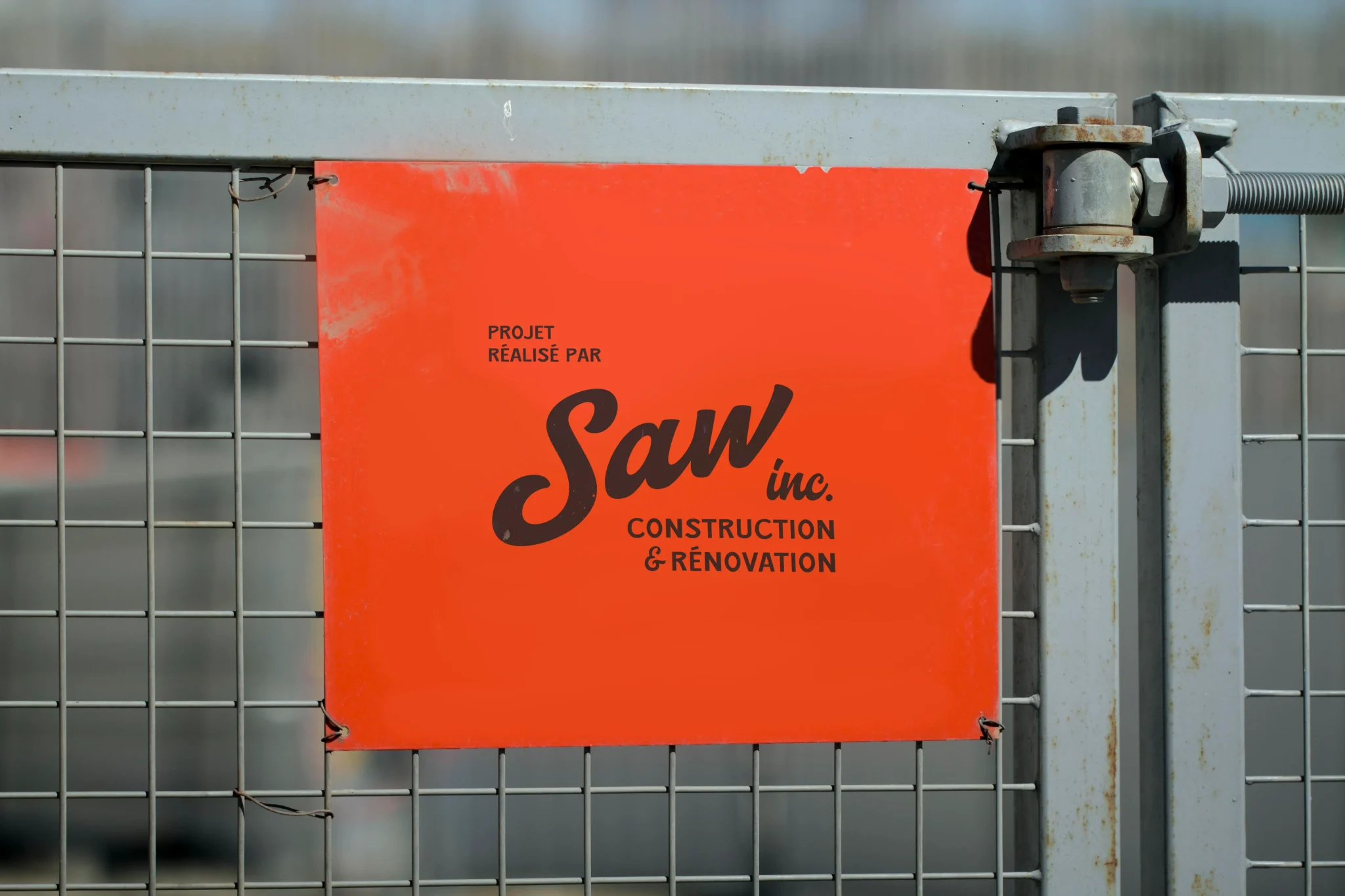 Exemple d'affichage extérieur pour SAW inc., mettant en valeur l'identité visuelle sur les chantiers de construction.